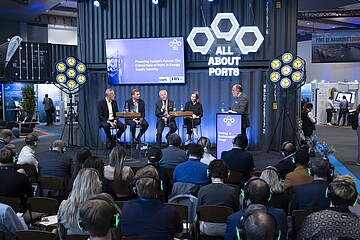 Podiumsdiskussion auf der Messebühne „All About Ports“ vor Fachpublikum während einer Branchenveranstaltung.