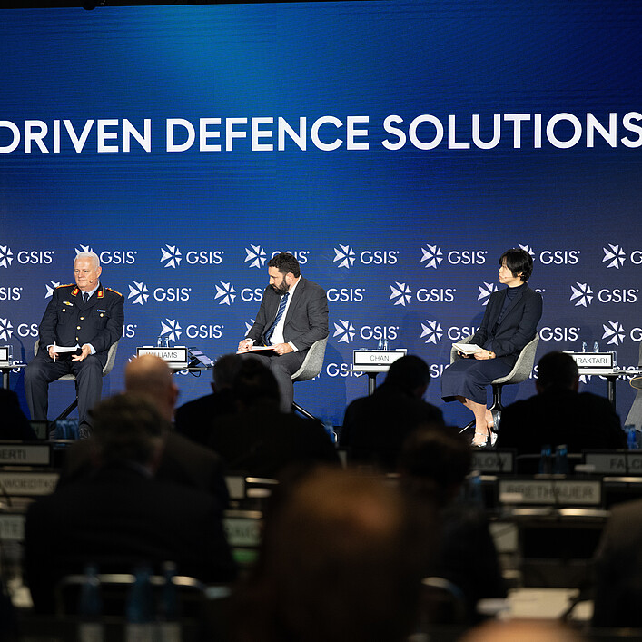 Podiumsdiskussion bei einer Konferenz mit dem Titel „AI-Driven Defence Solutions“, vier Personen auf einer Bühne vor Publikum.